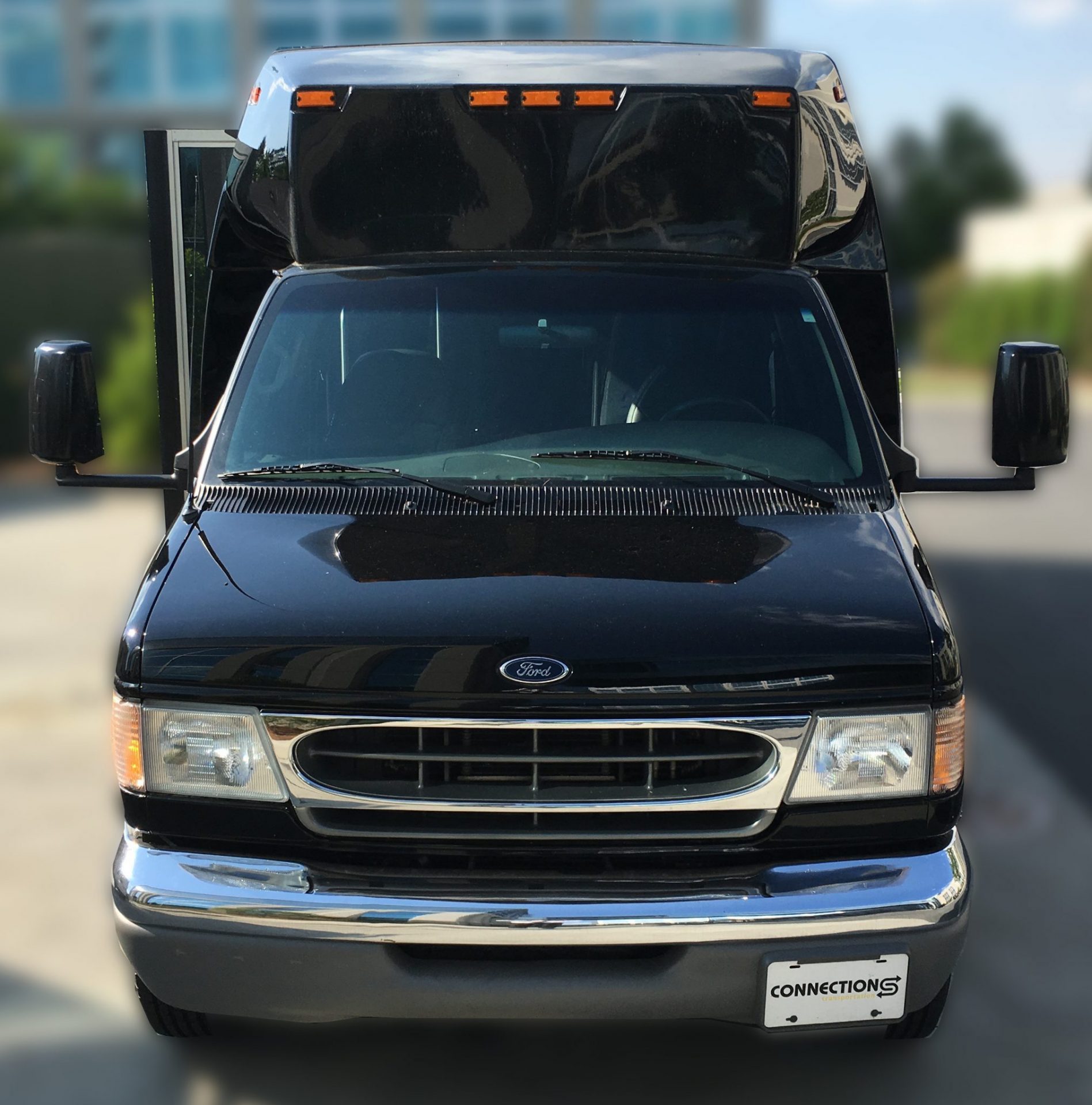 Black Ford E-series 23-passenger mini-bus, head-on, with a Connections license plate